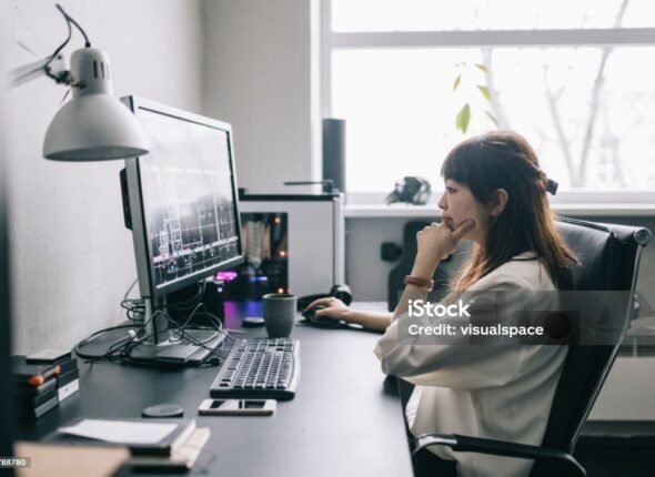 Female architect working on blueprints at the office.